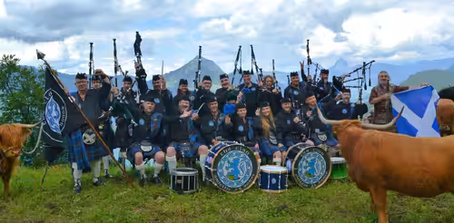 Dudelsackband THE CLAN in Schottenröcken mit Hochlandrindern